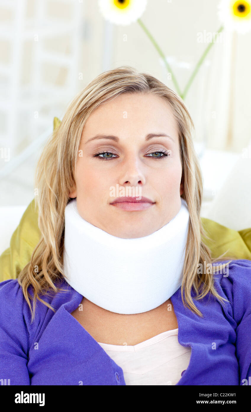 Attractive woman wearing neckbrace lying on a sofa Stock Photo - Alamy