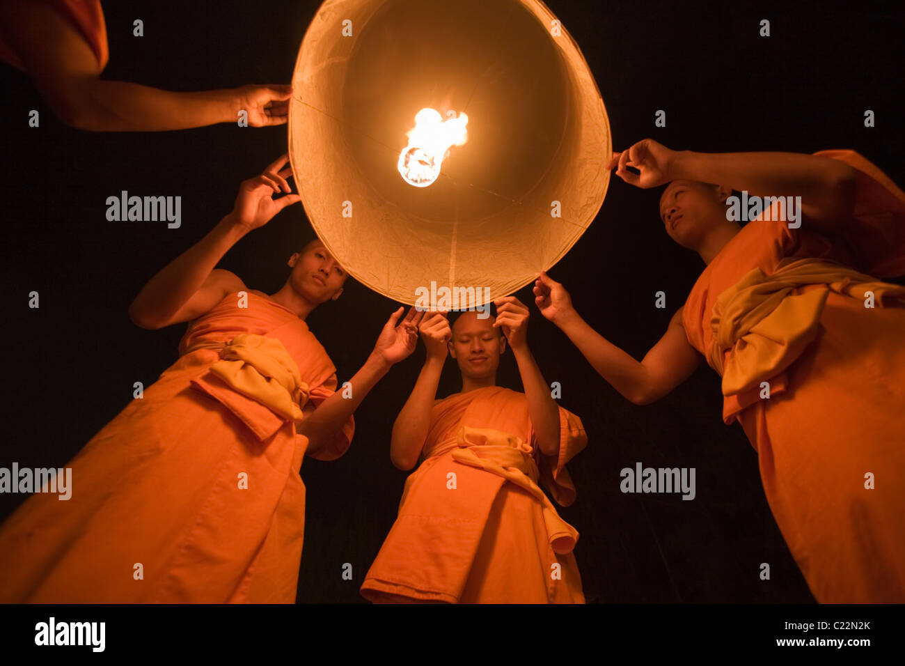 Monks launch khom loi (sky lanterns) into the night sky during the Yi Peng festival.  San Sai, Chiang Mai, Thailand Stock Photo