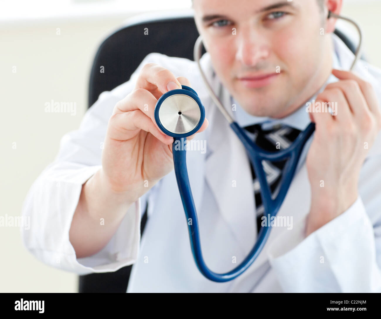 Portrait of a charming male doctor holding a stethoscope Stock Photo ...