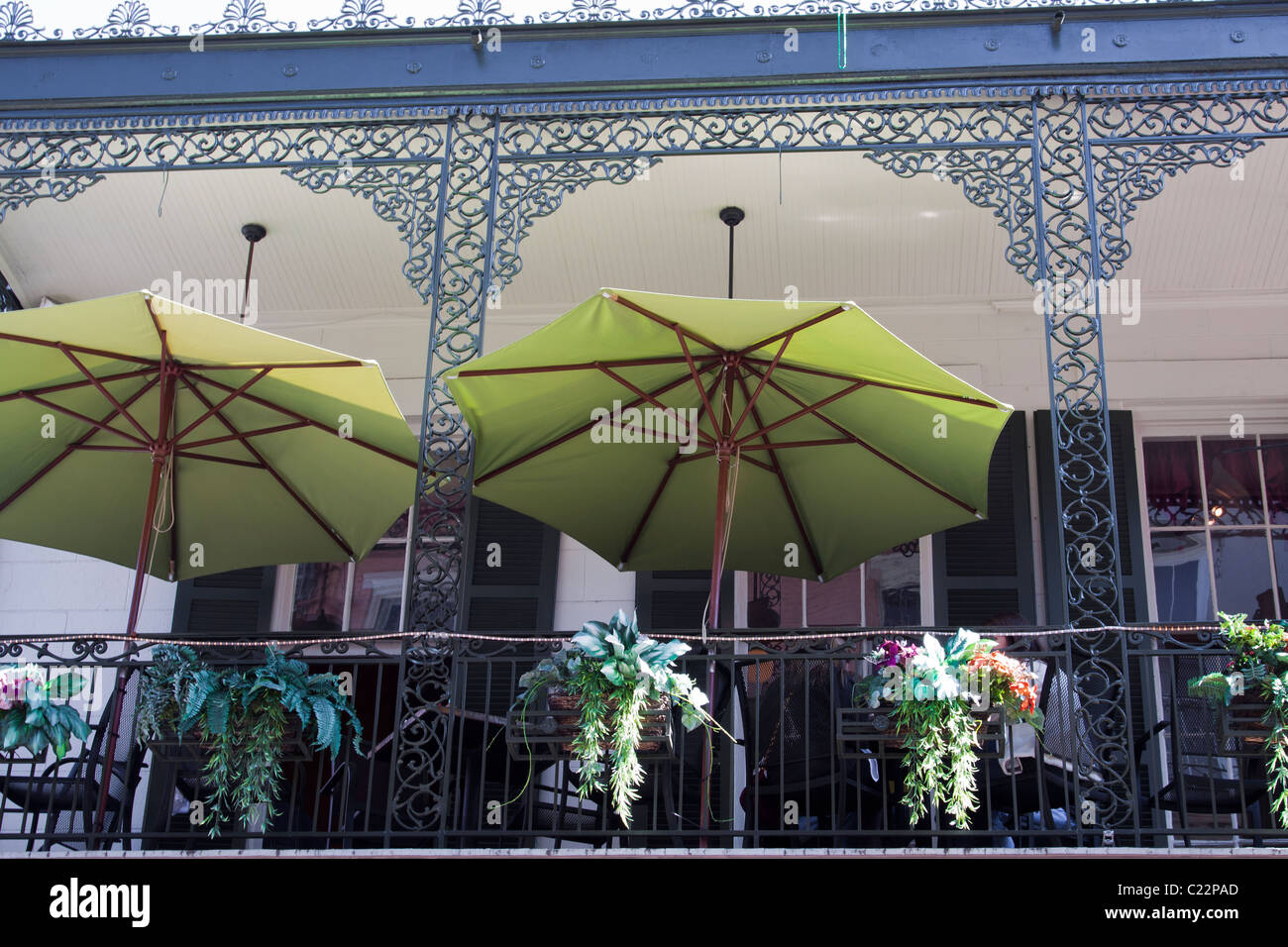 Green umbrellas opened on the upstairs balcony dining area at La Bayou Cafe in the French Quarter of New Orleans Stock Photo