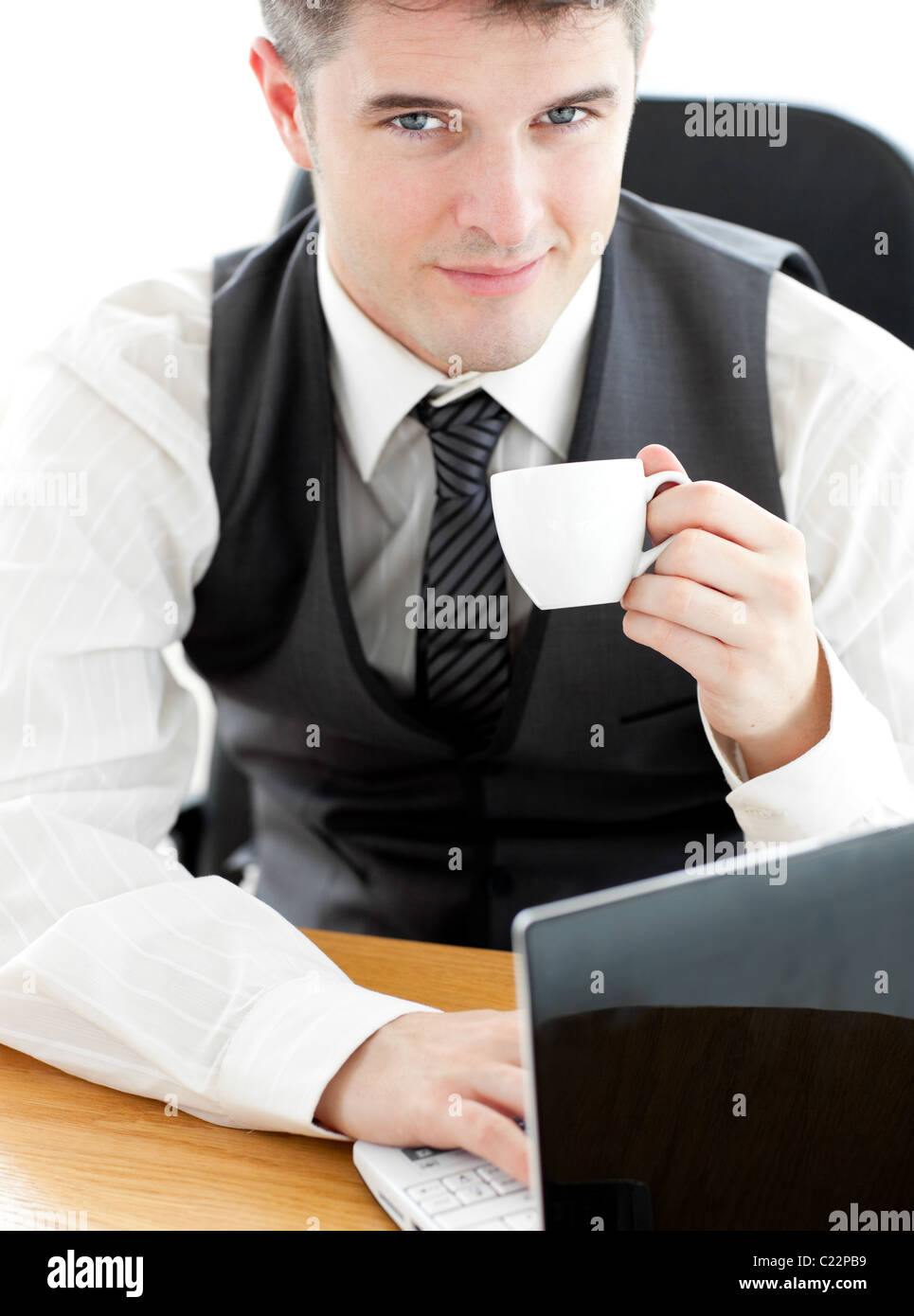 Jolly young businessman looking at the camera holding a coffee Stock ...