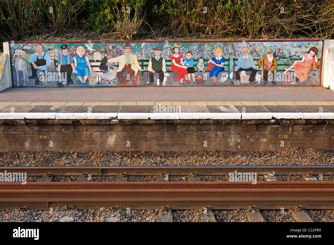 Painted mural depicting passengers waiting for a train at a station in Essex, England. Stock Photo