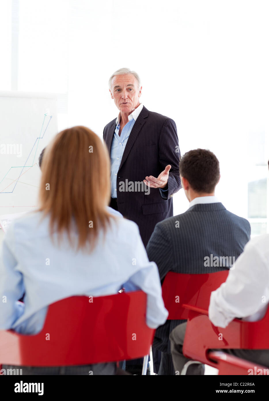 Senior businessman giving presentation team hi-res stock photography ...