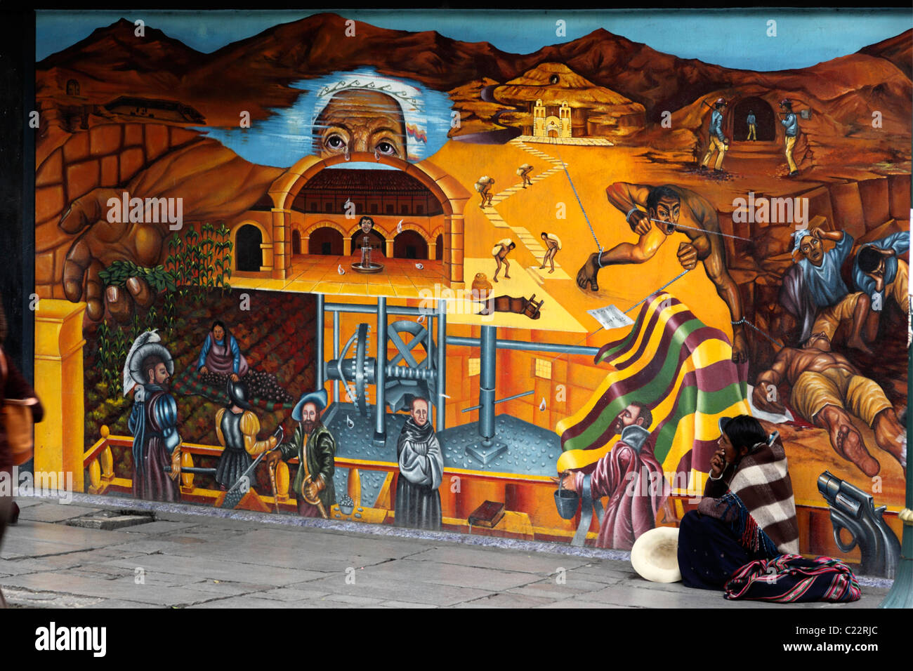 Lady from Potosi region begging in front of mural showing repression of natives in Potosi silver mines back in colonial times, La Paz, Bolivia Stock Photo