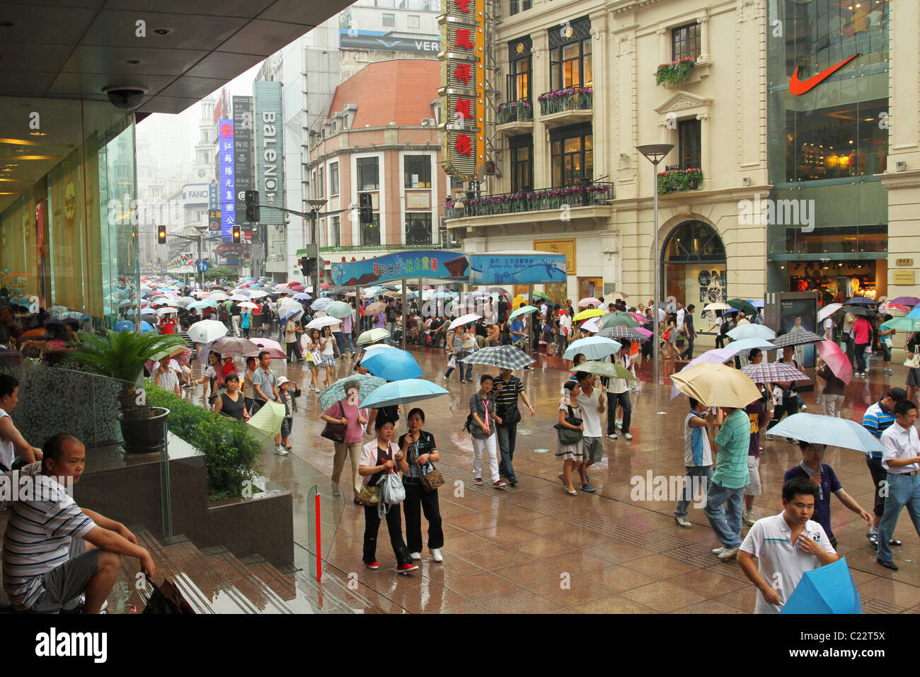 People with Umbrellas on rainy day on Nanjing Road, Pushi, Shanghai, China. Stock Photo
