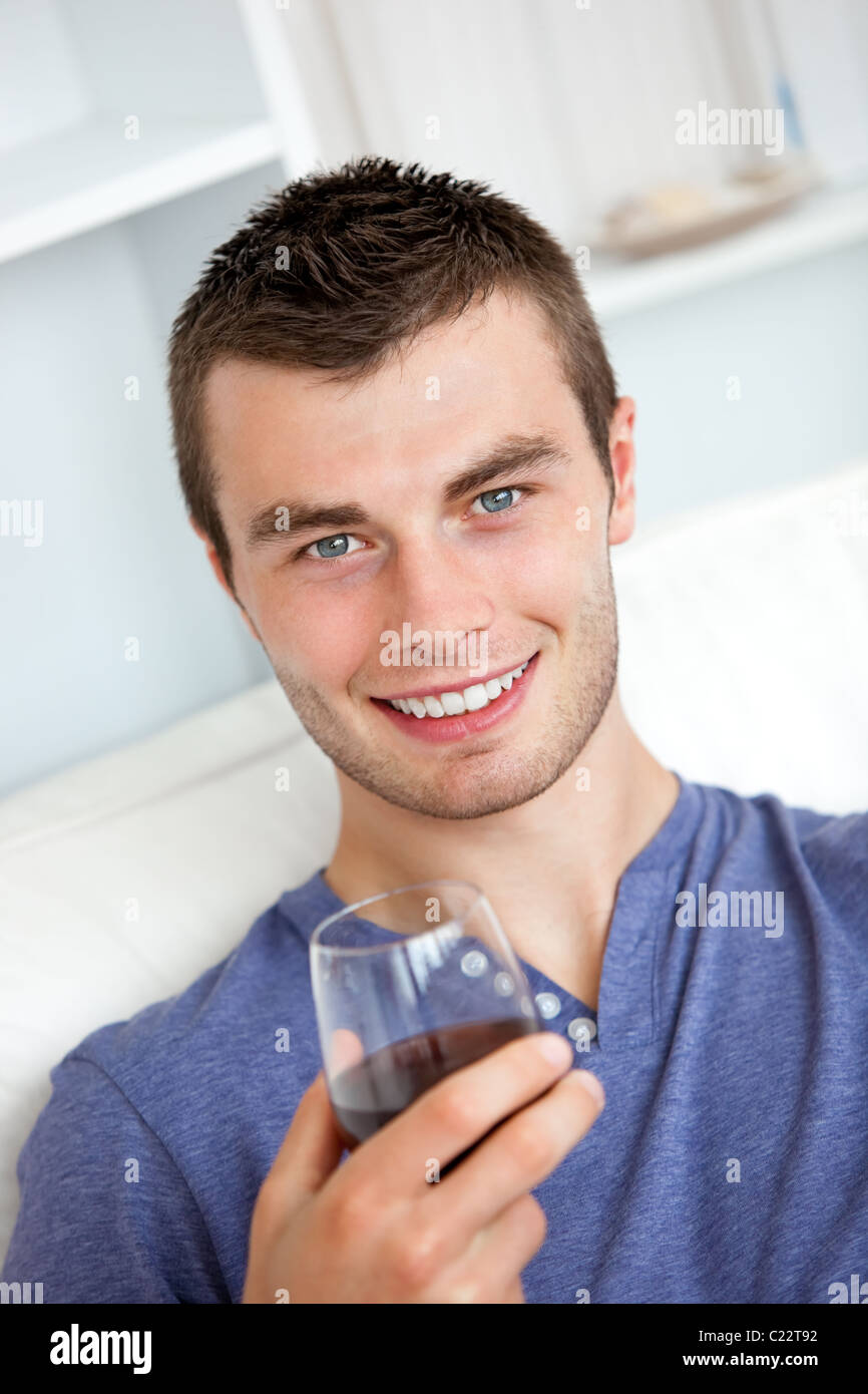 Animated young man drinking wine looking at the camera sitting on the ...