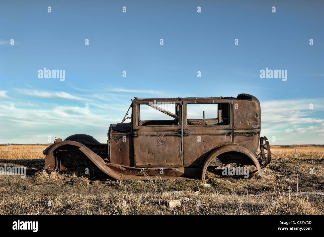 A rusted 1920's vintage antique automobile abandoned in a field in Alberta, Canada. Stock Photo