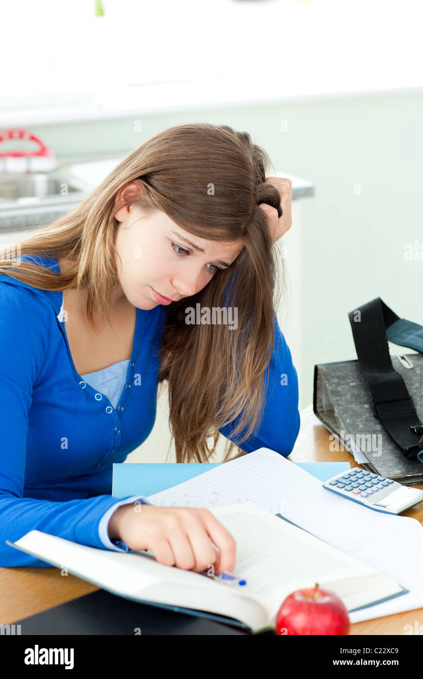 Stressed student doing her homework on a desk Stock Photo - Alamy
