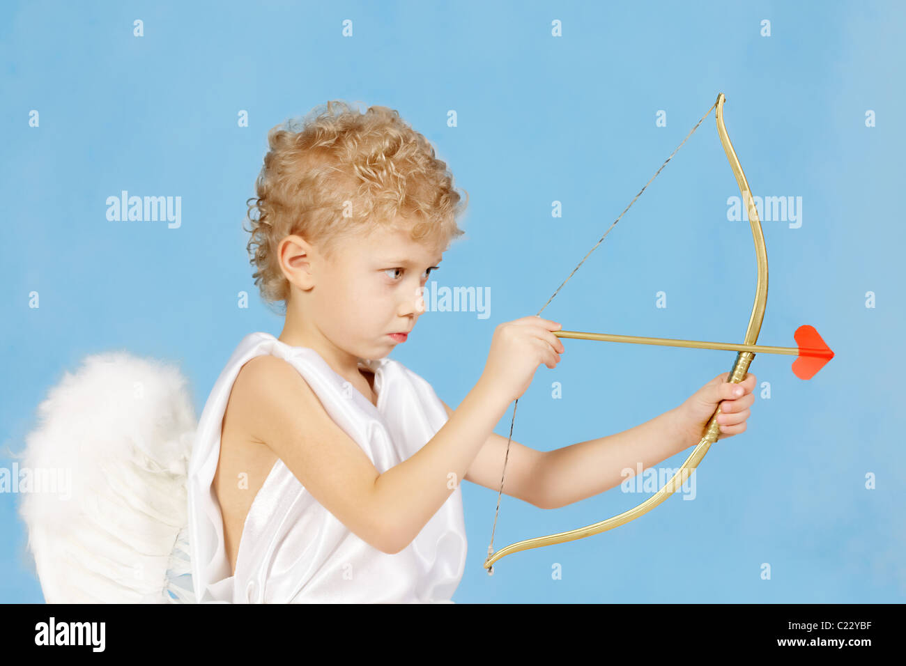 Portrait of little boy with bow and arrow ready to make someone fall in