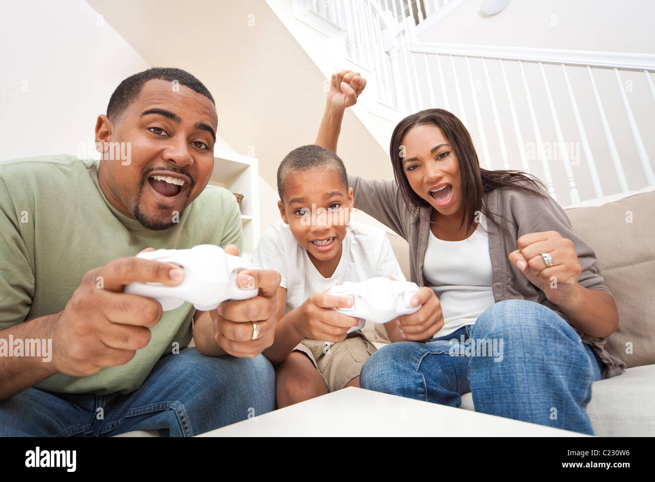 African American family, parents and son, having fun playing video console games together Stock Photo
