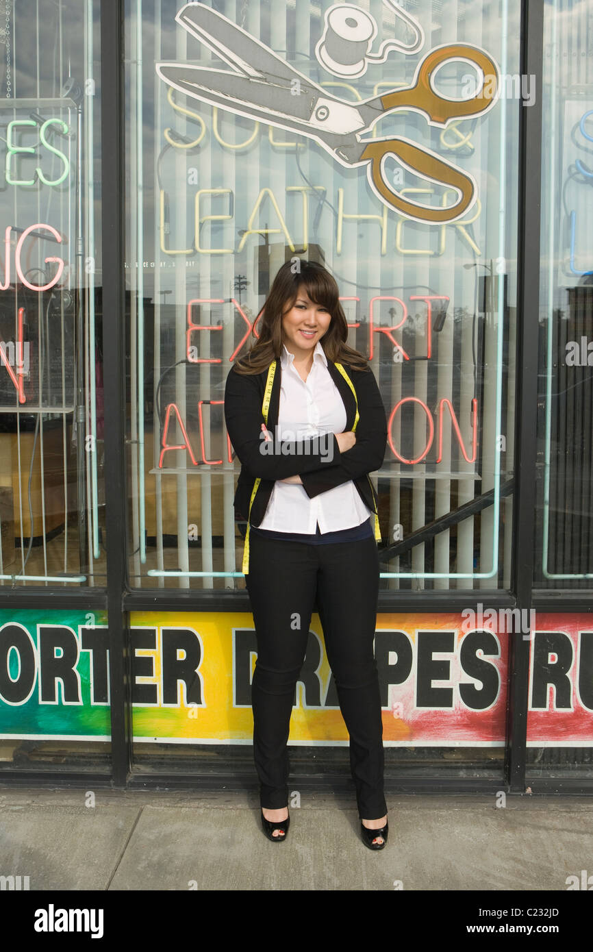 Woman standing infront of laundrette shop window Stock Photo