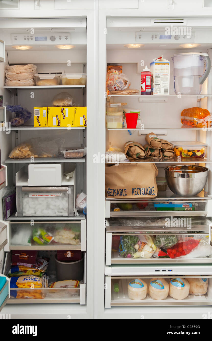 Stacked products in open fridge Stock Photo