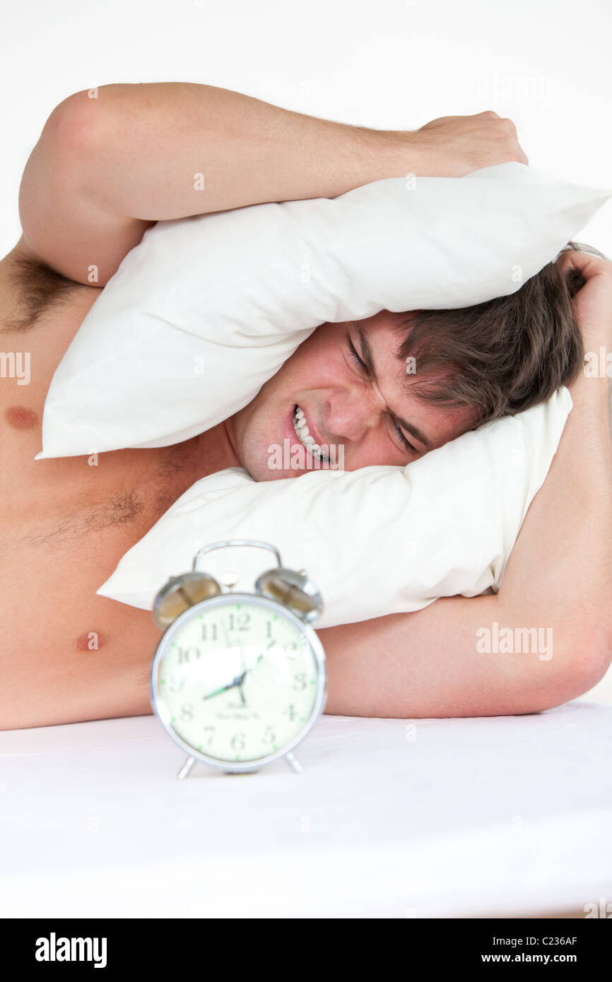 Angry Man Woken Up By His Alarm Clock Putting Pillow On His Head