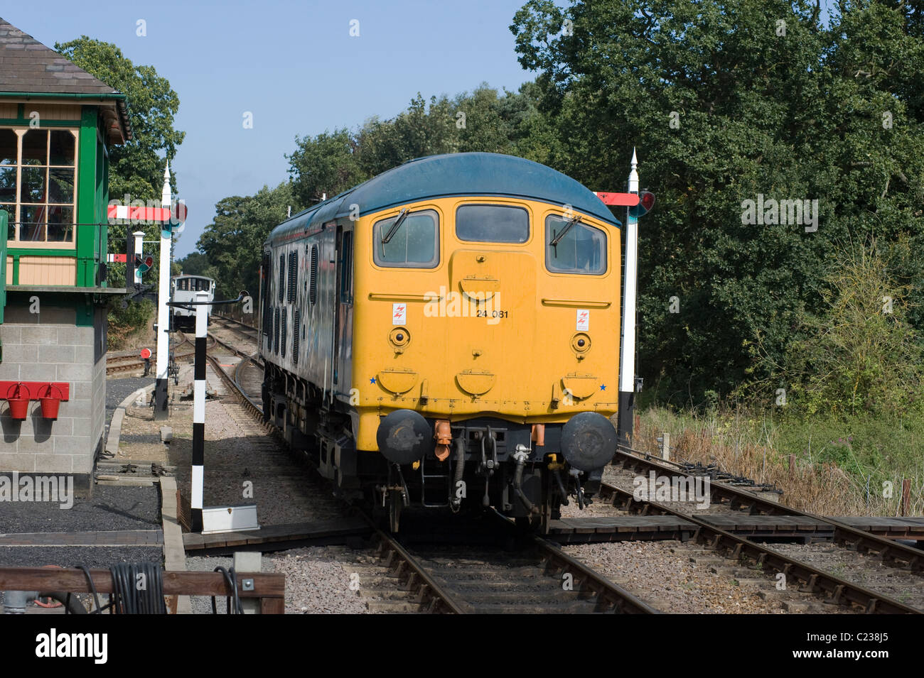 railway engine travels past signal at stop holt norfolk Stock Photo
