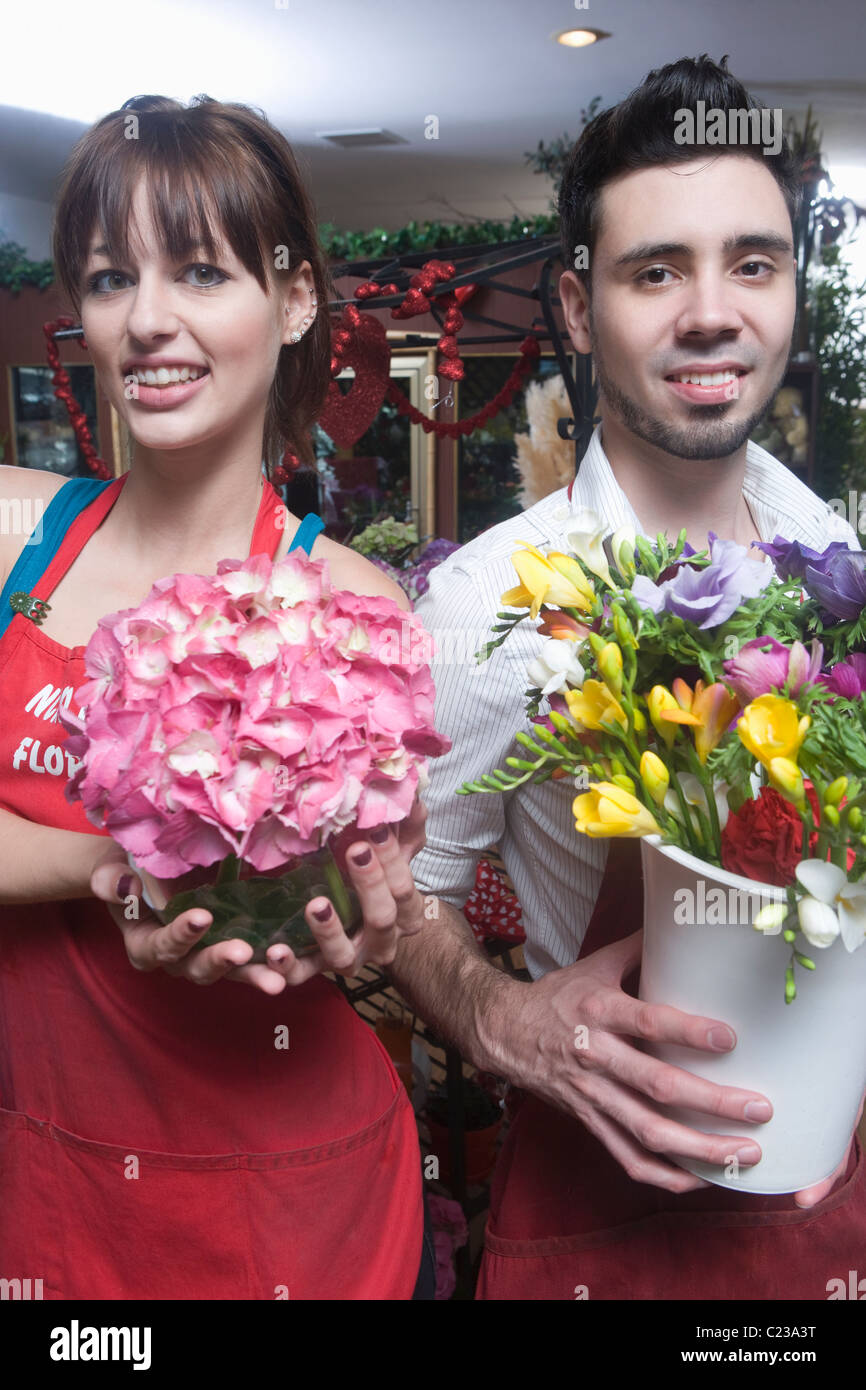 Florists stand holding a bucket of cut flowers and a hydrangea Stock Photo