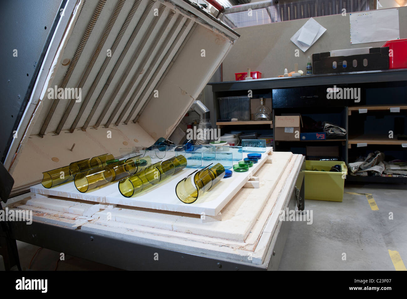 An electric kiln filled with old glass bottles ready to be melted into