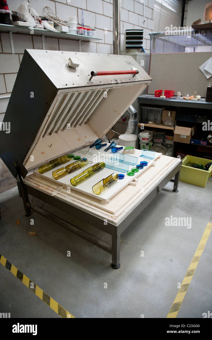 An electric kiln filled with old glass bottles ready to be melted into