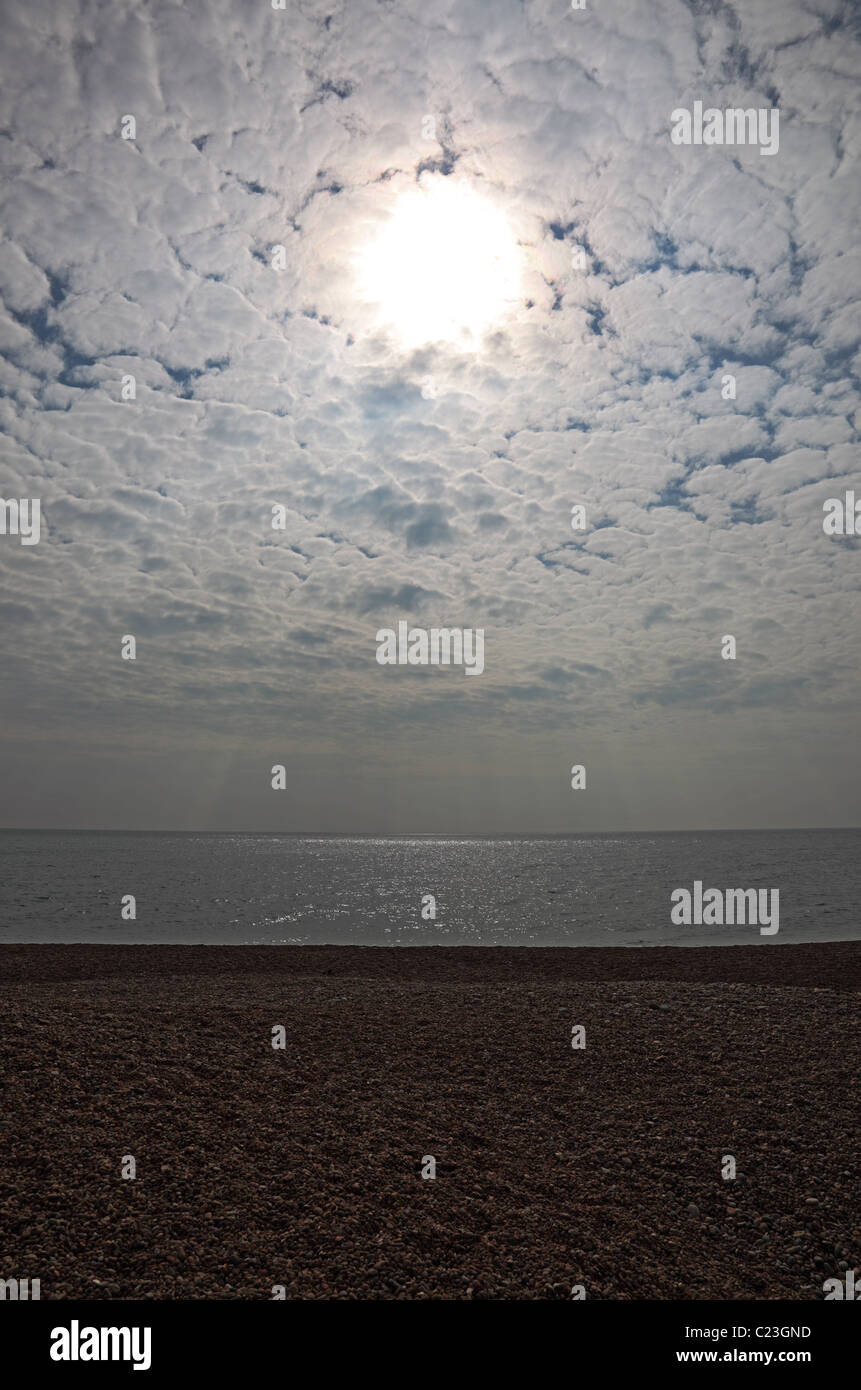 Sun over sea on overcast day Stock Photo