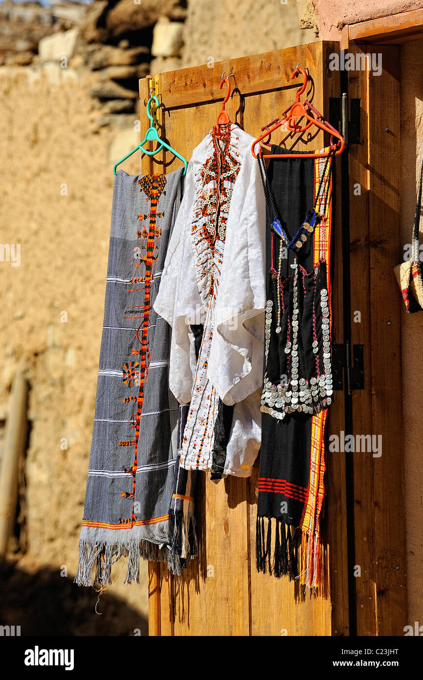 Typical Arab clothes on hangers hanging on a door of a shop in a street