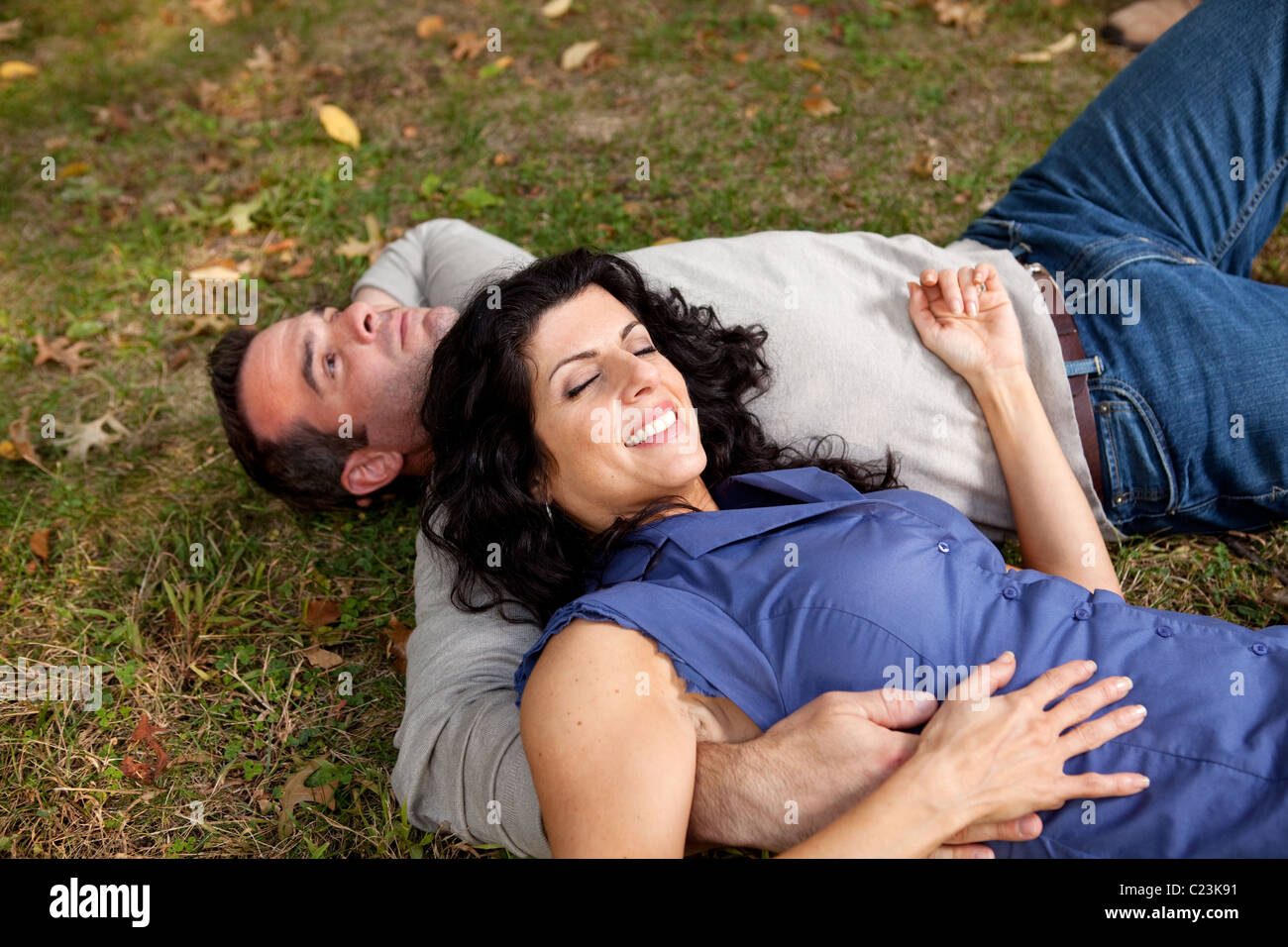 A couple laying on grass in a park Stock Photo - Alamy