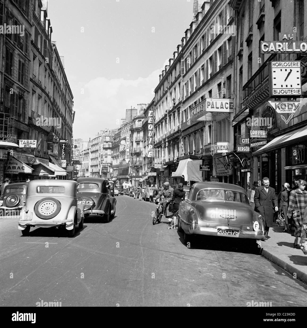 Paris, France, picture from the 1950s, looking down the Rue du Faubourg, Montmartre, showing parisians and motorcars of the era. Stock Photo