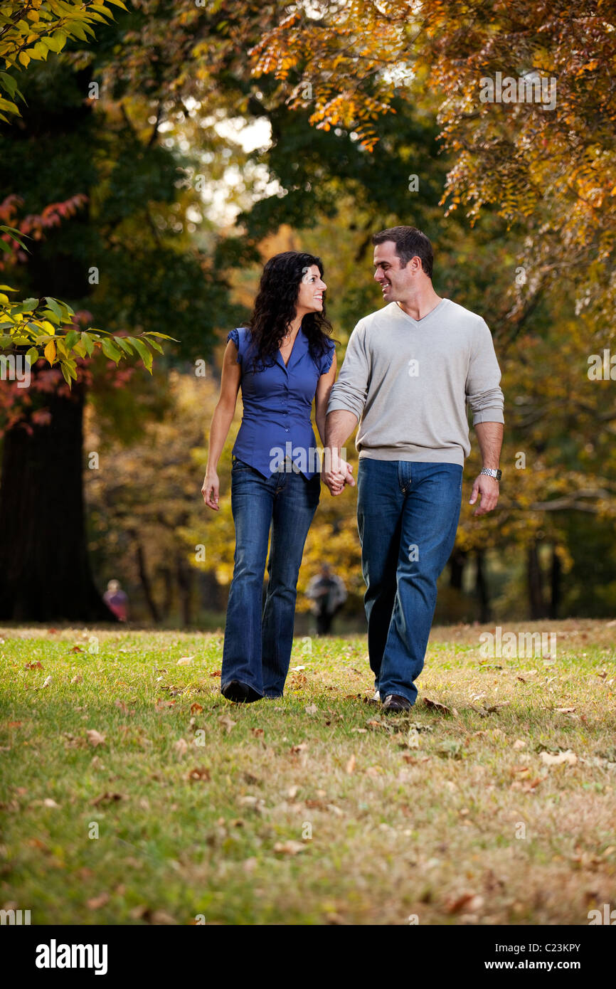 A happy couple walking in the park on grass Stock Photo - Alamy