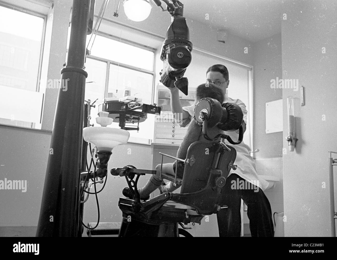 1950s. London, England. Dentist working on a child's teeth in this