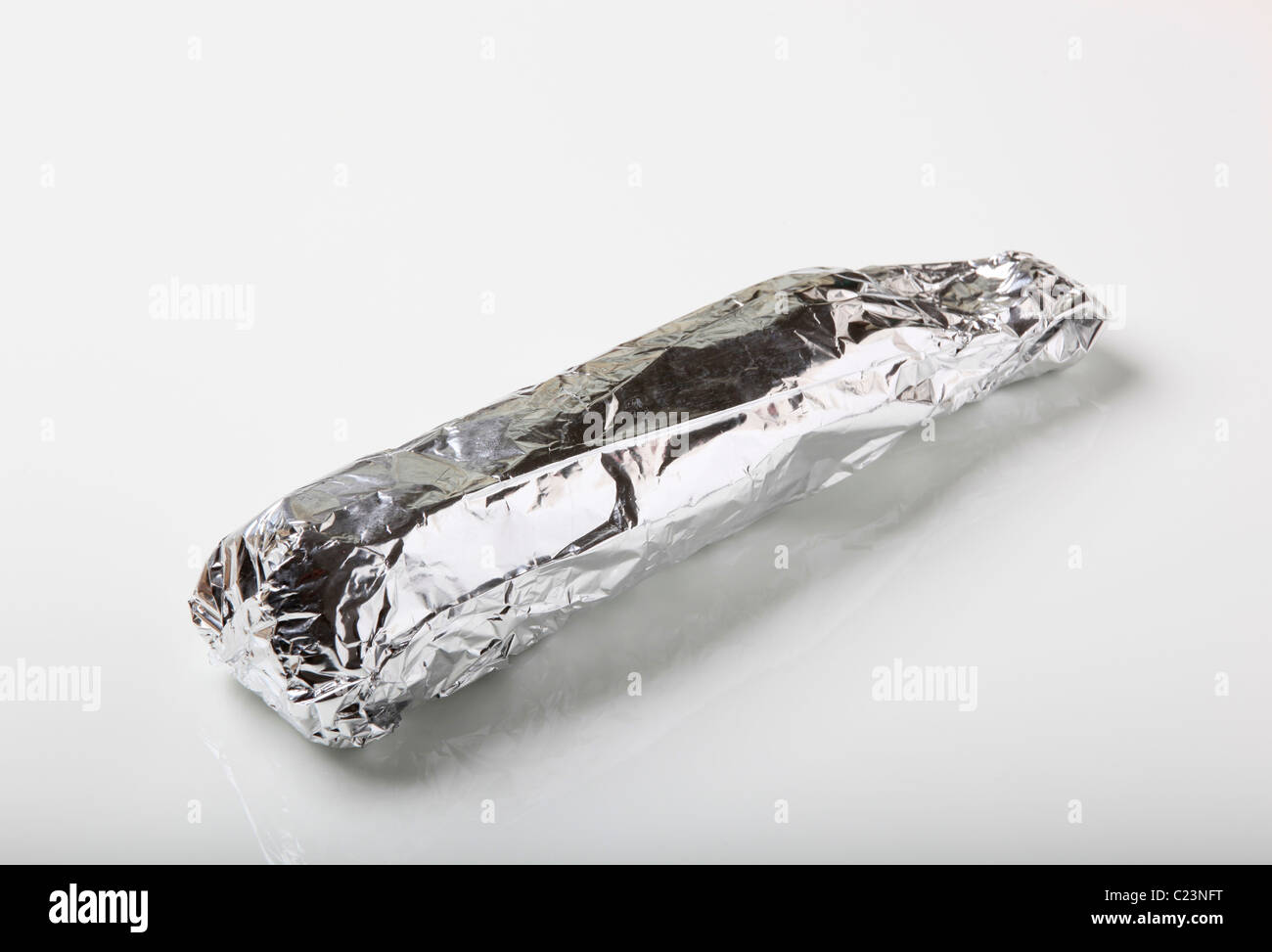 Raw pork tenderloin wrapped in aluminum foil Stock Photo