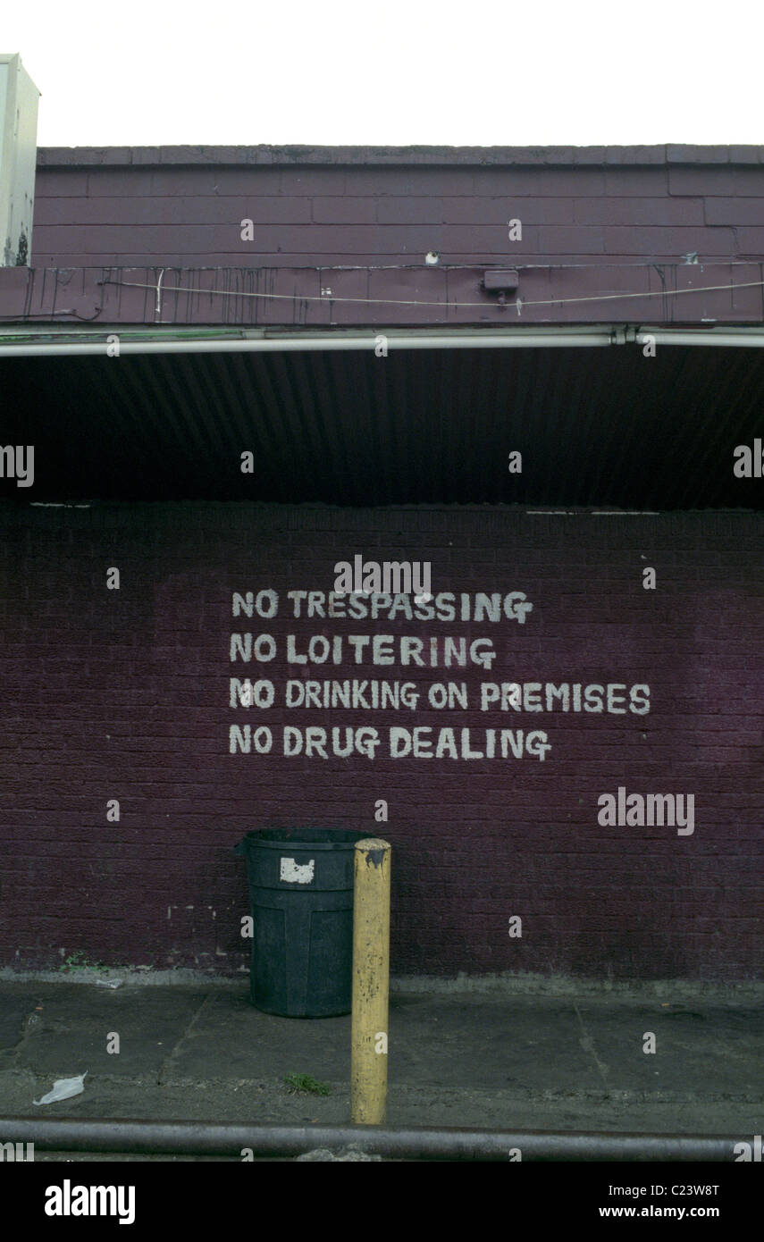 Warning notice on side of building prohibiting drinking loitering or drug dealing Stock Photo