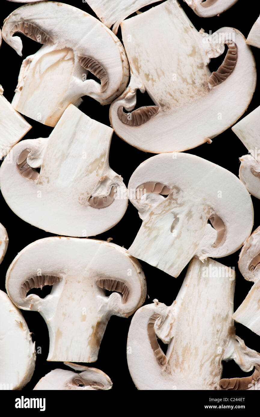 Macro detail background of sliced champignon mushrooms on black Stock Photo