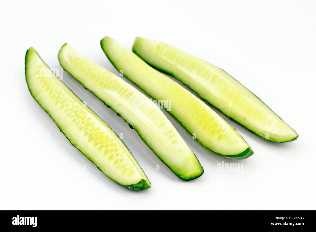One organic green vegetable sliced in quarters lengthwise. One cucumber
