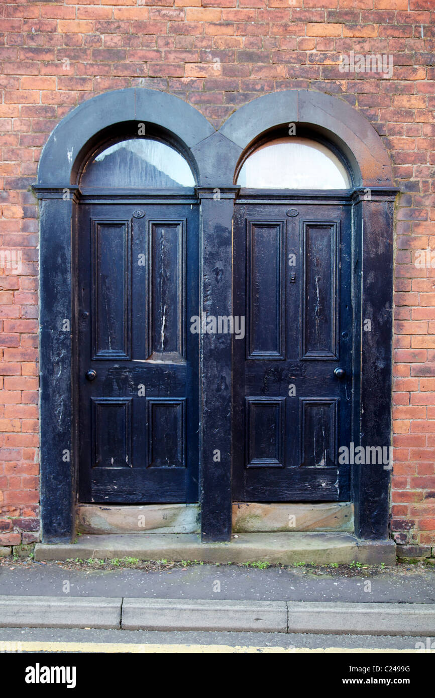 2 black doors next to each other in terrace of houses Stock Photo