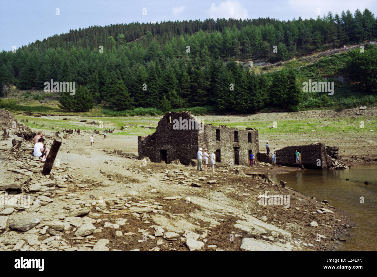 Visitors looking at Fannog farmhouse in Llyn Brianne Reservoir exposed in the summer drought of 1995 Mid Wales UK Stock Photo