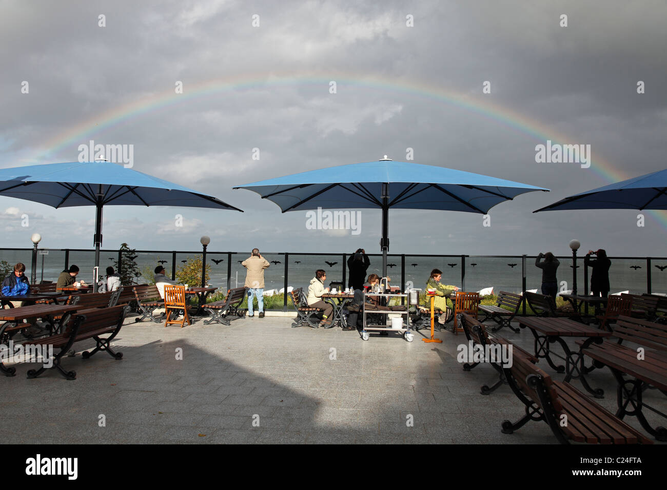 rainbow over Baltic Sea seen from beach coffee house in Thiessow, Germany; Cafe and Restaurant am Strand in Thiessow Stock Photo