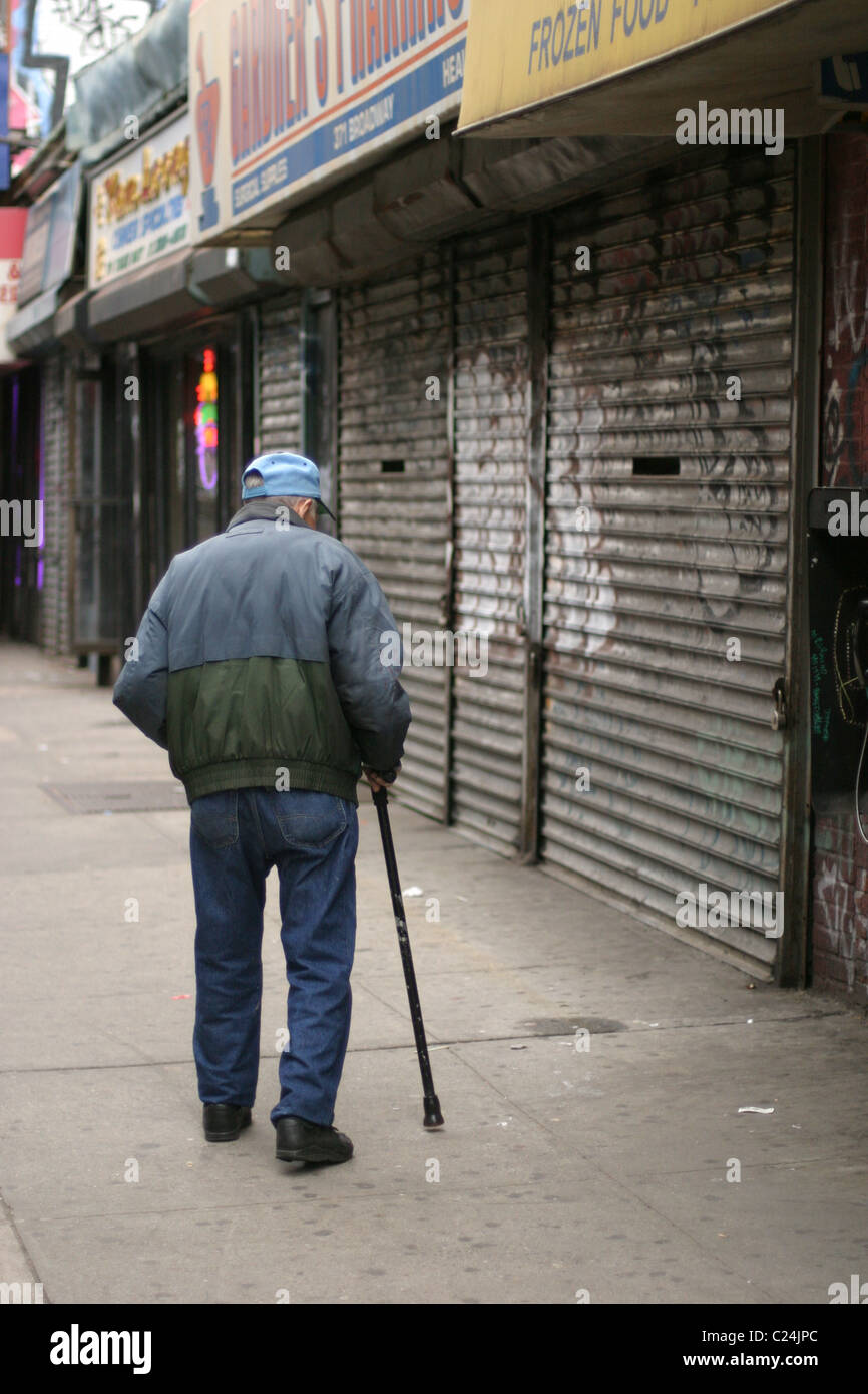 Old man with cane walking on the streets of New York City Stock Photo