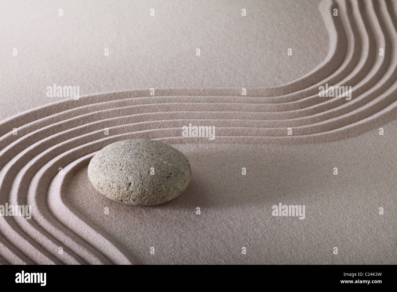 zen garden japanese garden zen stone with raked sand and round stone tranquility and balance ripples sand pattern Stock Photo