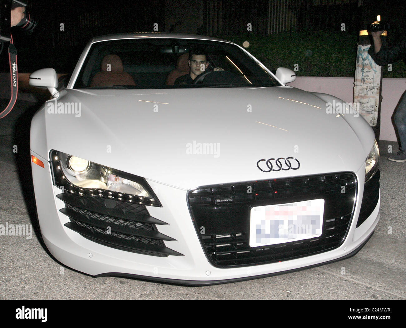 Taylor Lautner driving a new white Audi R8 as he leaves Alice & Olivia  boutique on Robertson Blvd after doing some shopping Stock Photo - Alamy