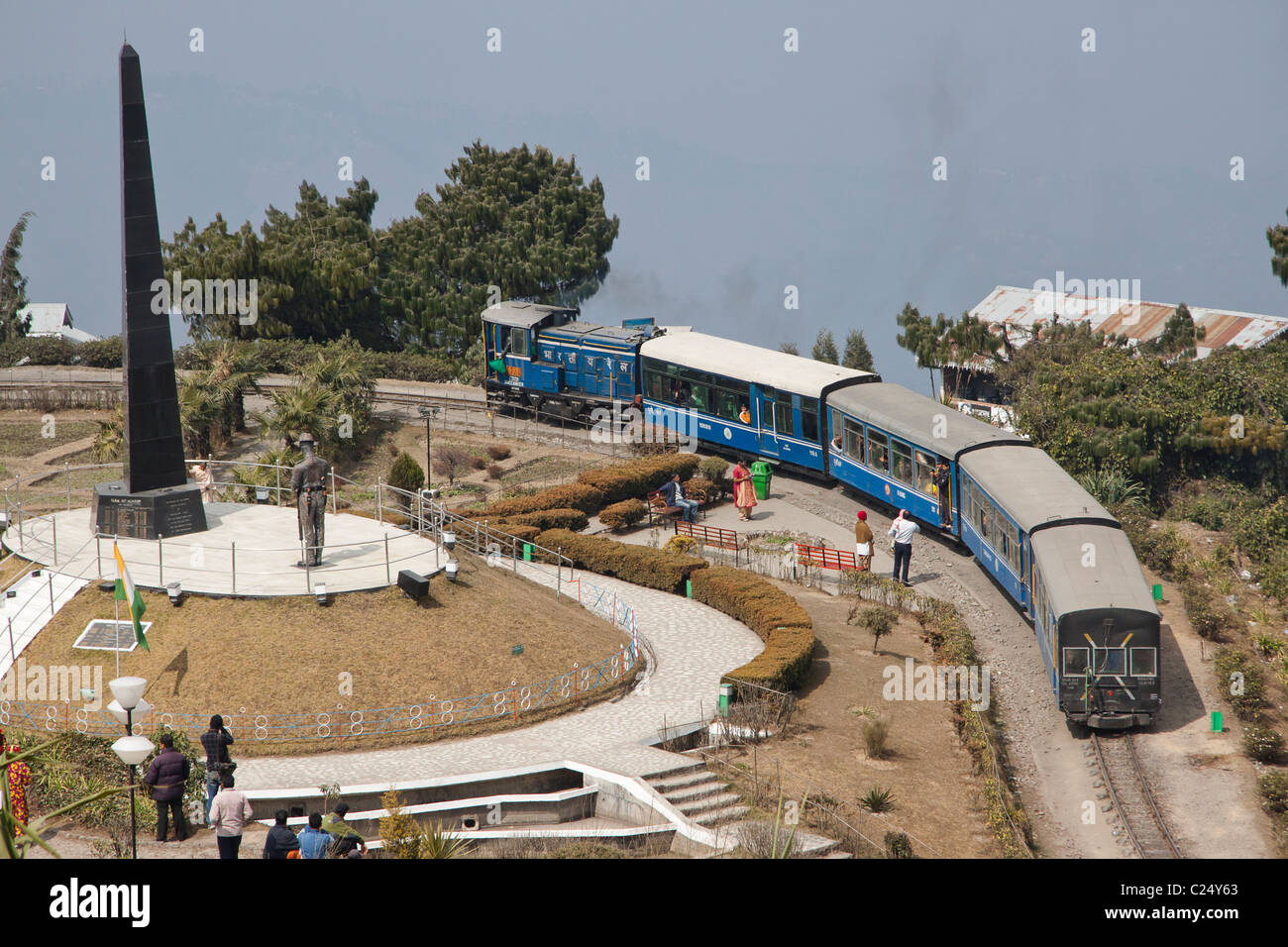 The toy train passes through Batasia loop and the war memorial in Darjeeling, West Bengal, India. Stock Photo