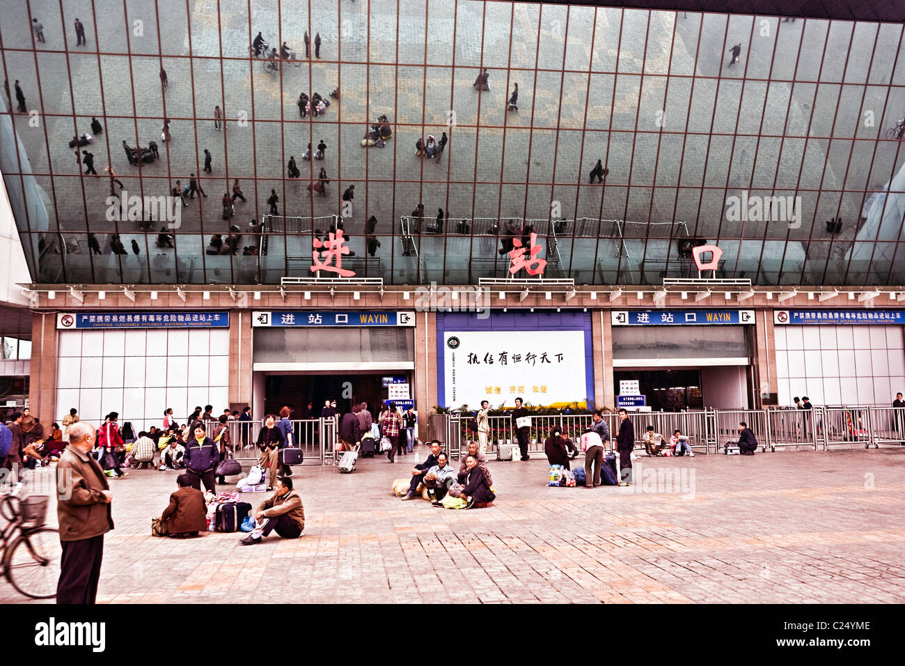 CHINA, WUHAN: Hankou Railway Station in Wuhan with plaza and people reflected in the mirrors on the front of the station. Stock Photo