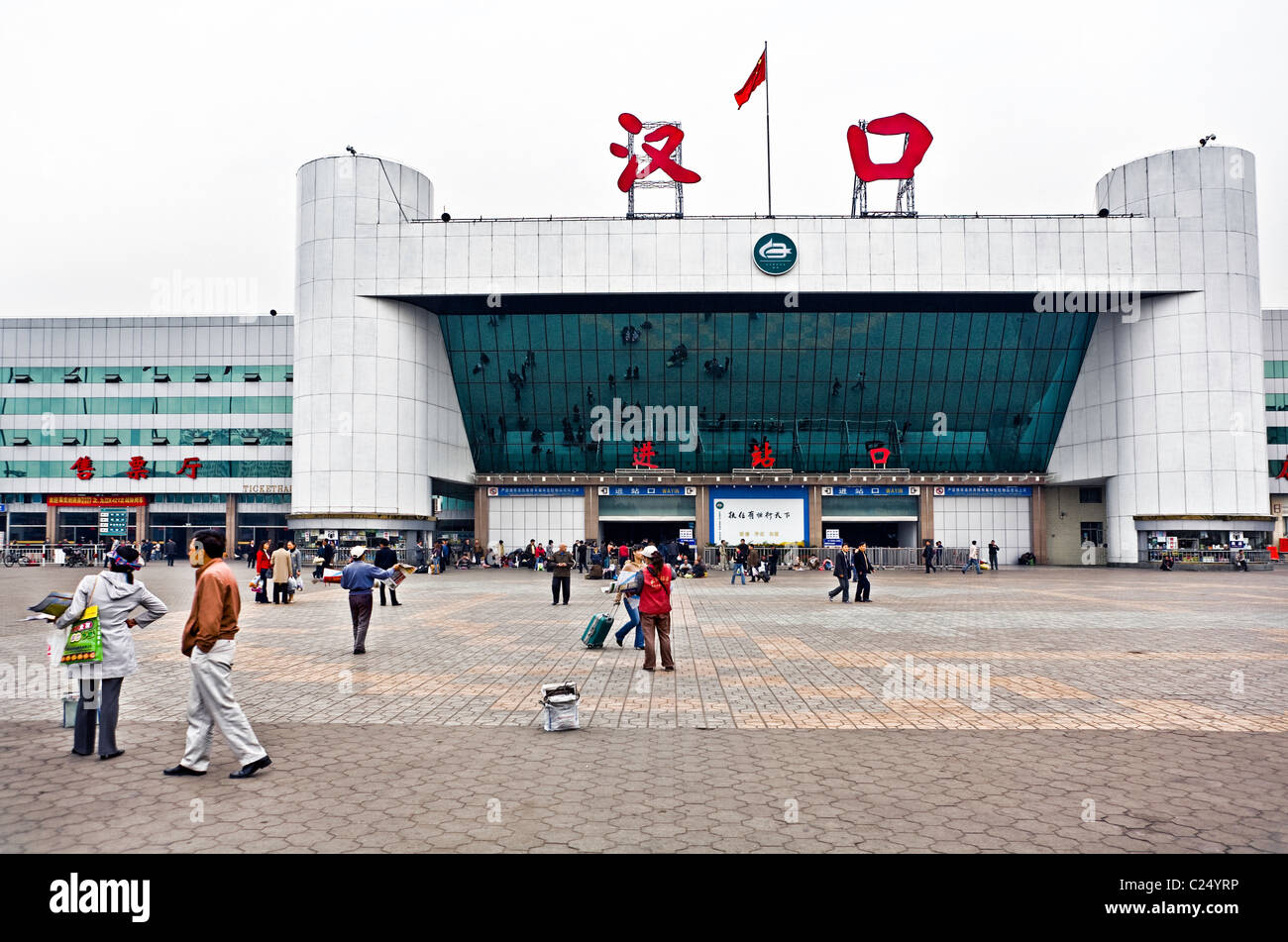 CHINA, WUHAN: Hankou Railway Station in Wuhan with plaza and people reflected in the mirrors on the front of the station. Photo Stock Photo