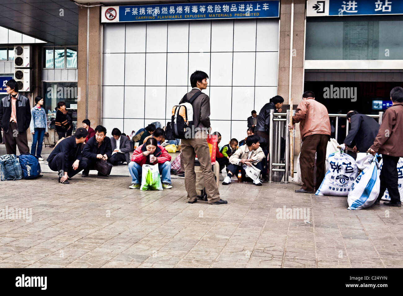 CHINA, WUHAN: Travelers with backpacks and luggage waiting outside the Hankou Railway Station in Wuhan as others clear security. Stock Photo