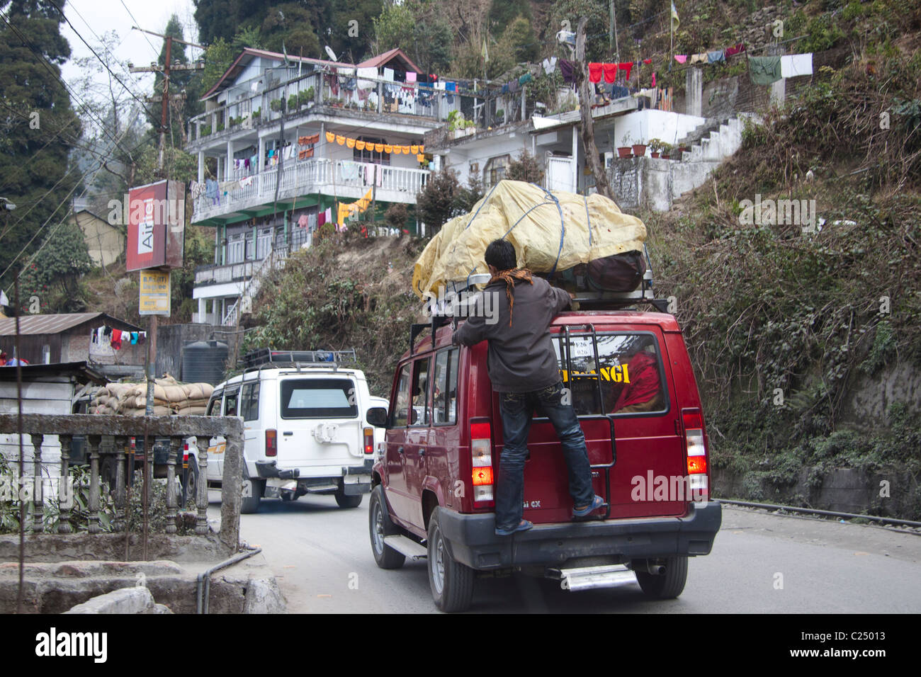 An overloaded red 'Tata Sumo' ferrying goods and passengers in Darjeeling, West Bengal, India. Stock Photo