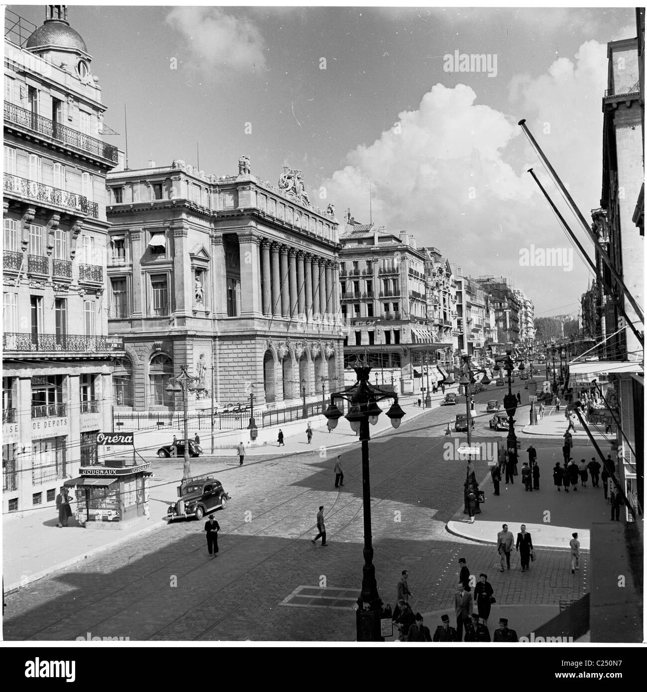 1950s, the cobbled La Canebiere, in the old quarter of Marseilles, France, the city's main street. Seen here the buildings, people and cars of era. Stock Photo