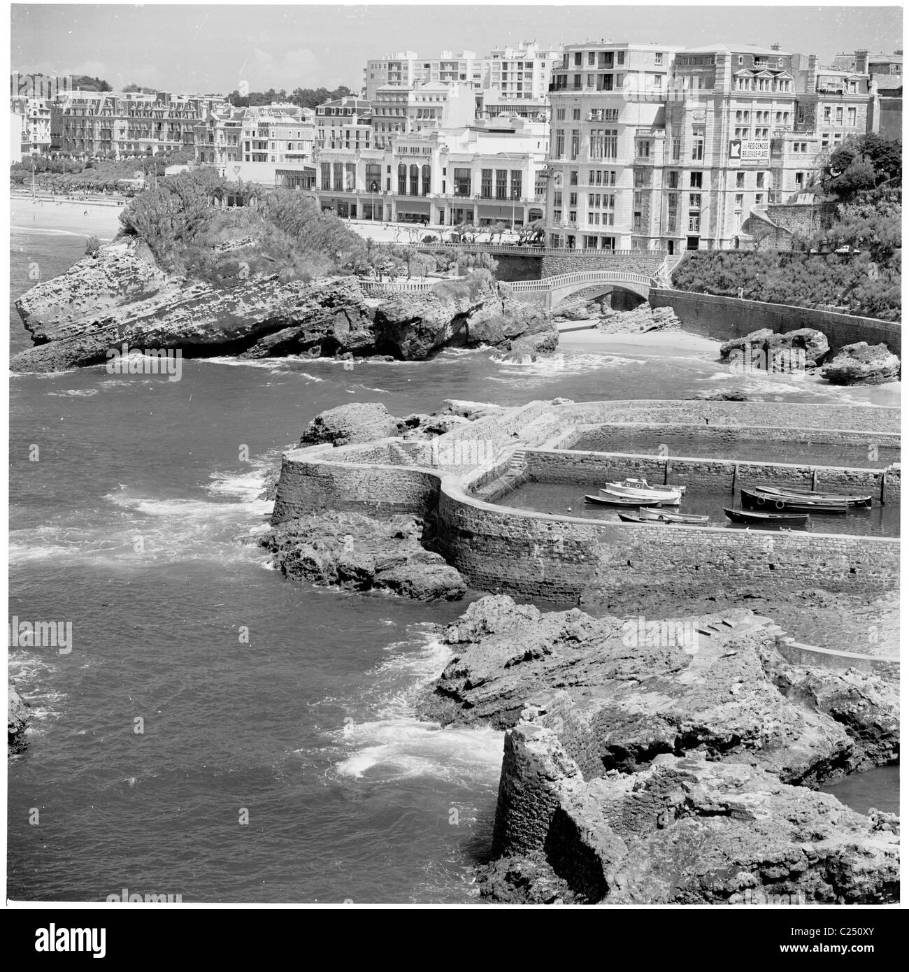 1950s, historical view of the rocky coast and seawall of the fisherman's port at the elegant seaside resort of Biarritz, France, on the Bay of Biscay. Stock Photo