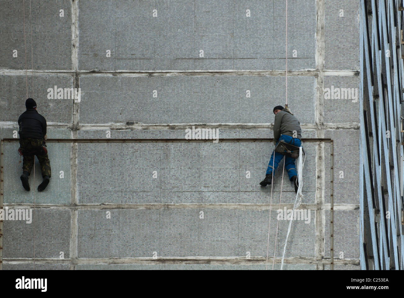 Two city climbers hang on the building wall. Moscow, Russia Stock Photo
