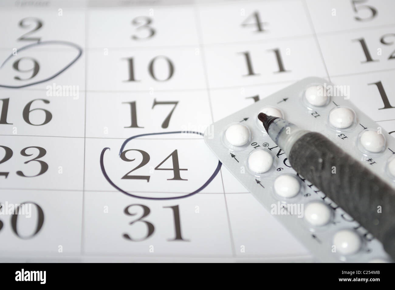 Birth control pills and pen closeup Stock Photo