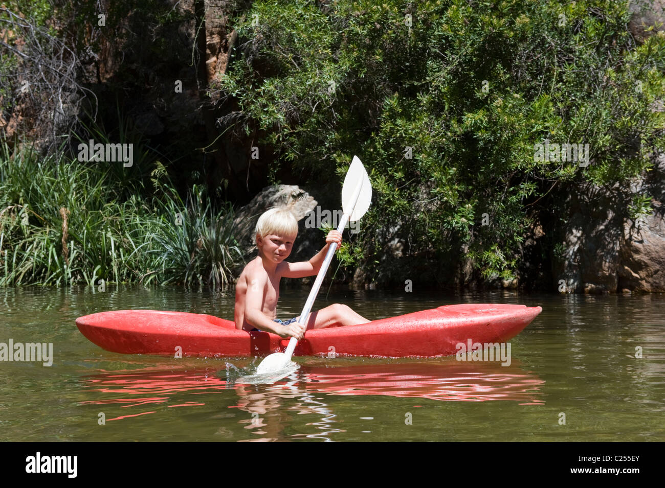 Boy paddling in a canoe on the Rondegat River, Cedarberg, Western Cape