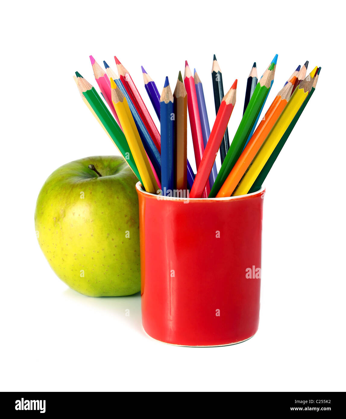 crayons coloured pencils and green apple isolated on white background Stock Photo