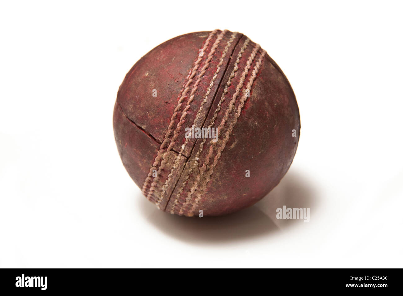 Red leather cricket ball isolated on a white studio background. Stock Photo