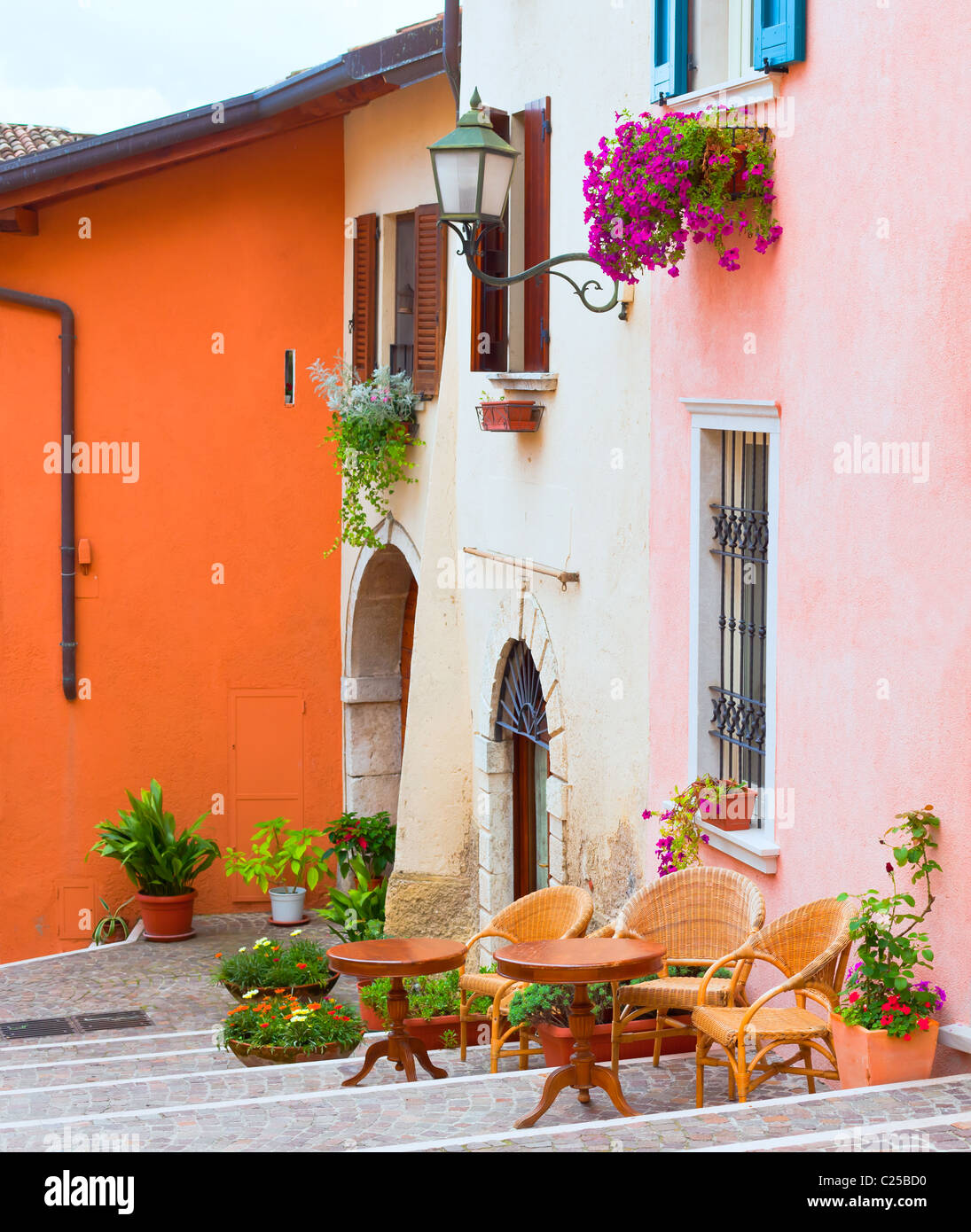 traditional italian small town street with pots of flowers and cafe Stock Photo